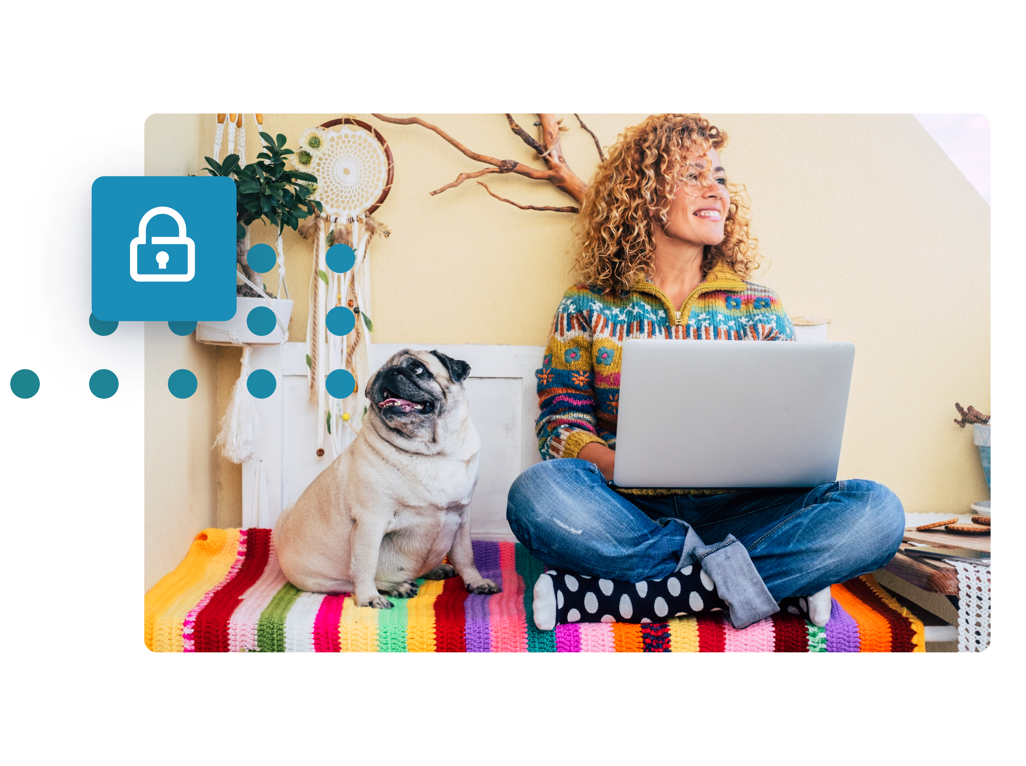 An image of a woman sat on the floor with her legs crossed and laptop in her lap. She is sat next to a pug and is smiling